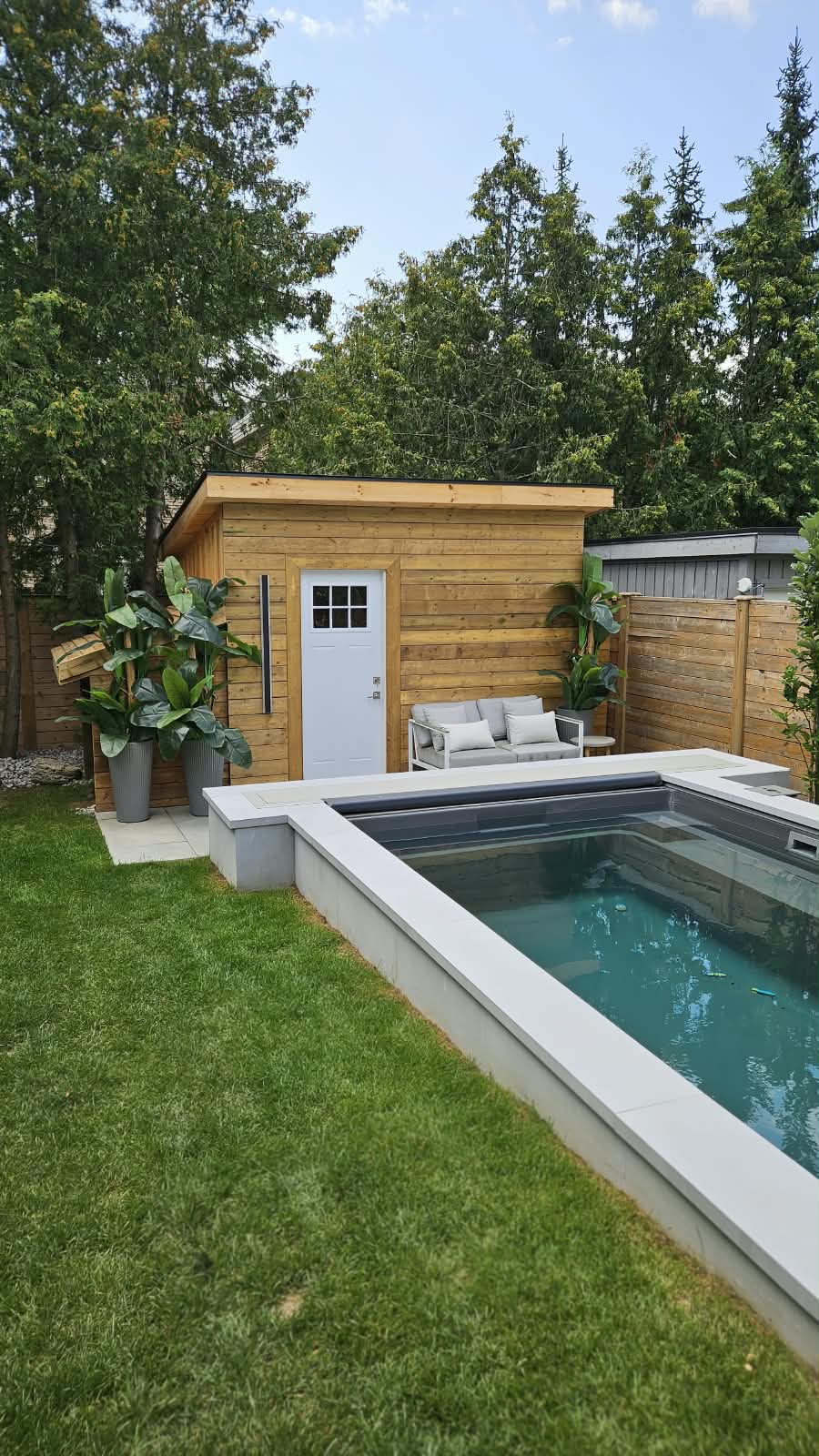 Custom cedar shed and privacy fence built beside a backyard pool in Toronto